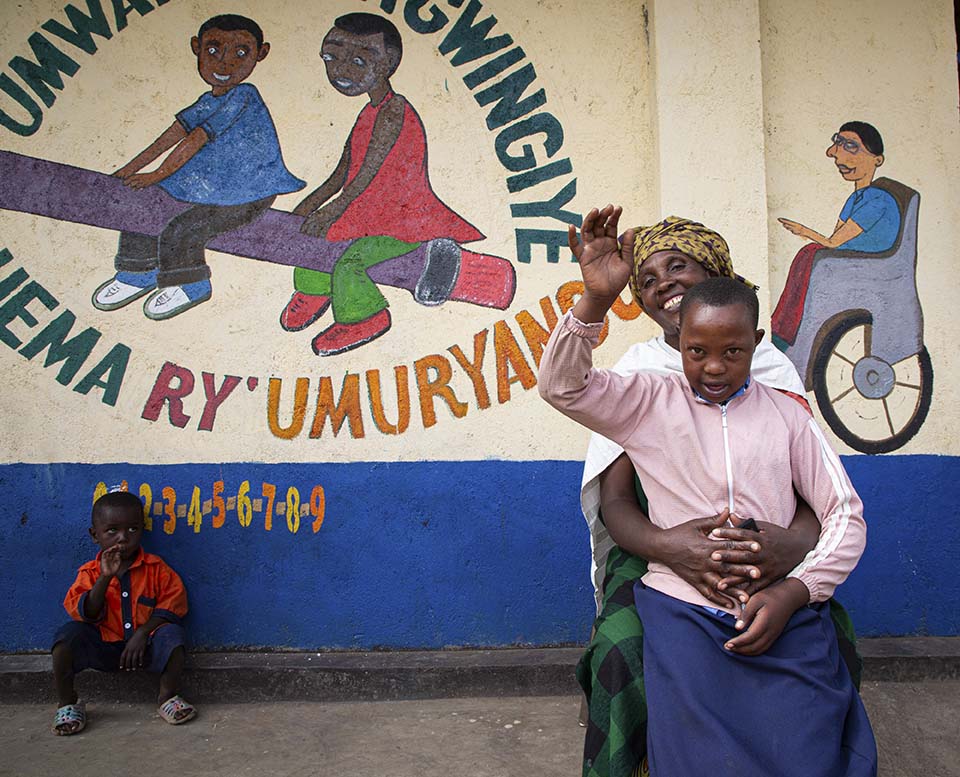 Rwanda mother and child sit outside school
