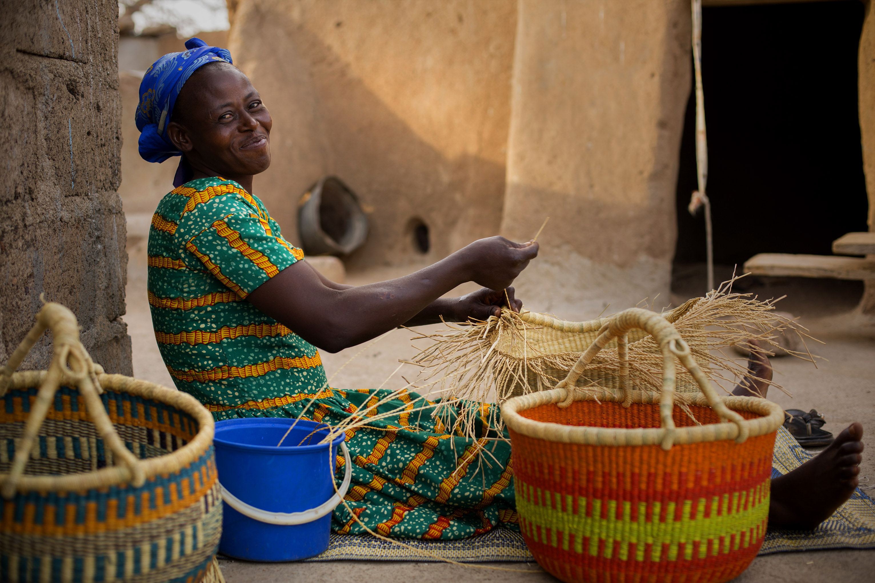 But thanks to a savings program, Nyaamah has a new dream: weaving straw baskets to sell to support her family. Photo by Jake Lyell for CRS