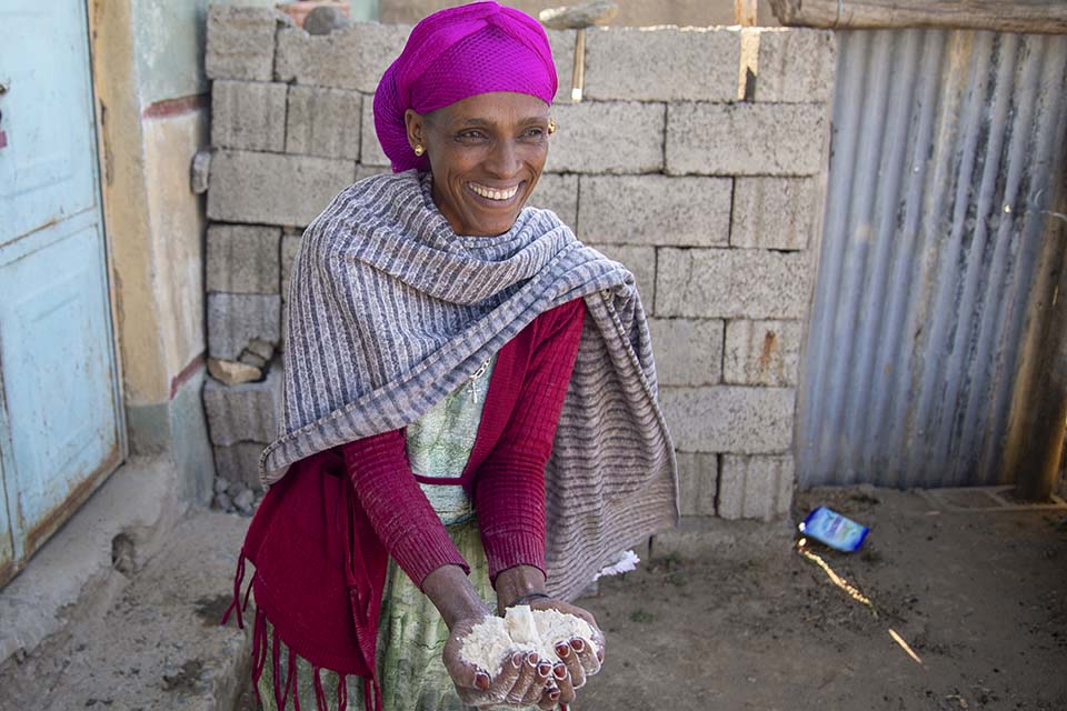 smiling woman at home holds wheat flour