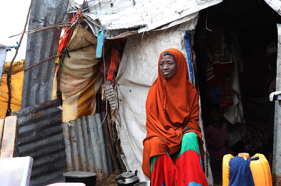 Somali woman sits outside tent