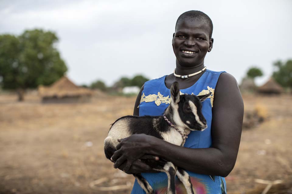 woman holds goat in South Sudan