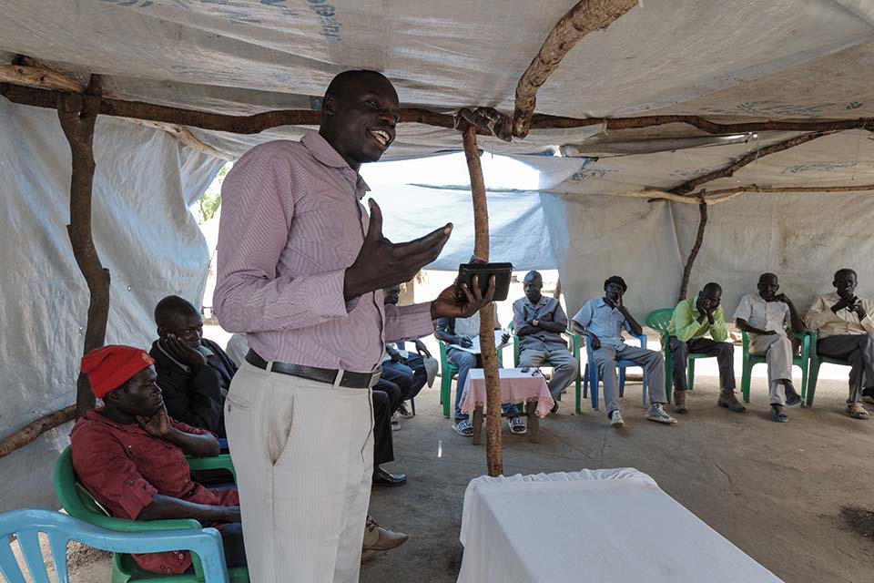 South Sudanese assistant pastor speaks to a gathering in Uganda