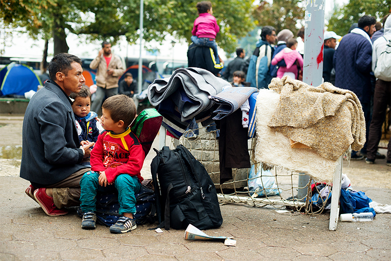 Refugee families wait for transportation to the Hungary border at a park in Belgrade, Serbia. Photo by Kira Horvath for CRS Refugee families wait for transportation to the Hungary border at a park in Belgrade, Serbia. Photo by Kira Horvath for CRS