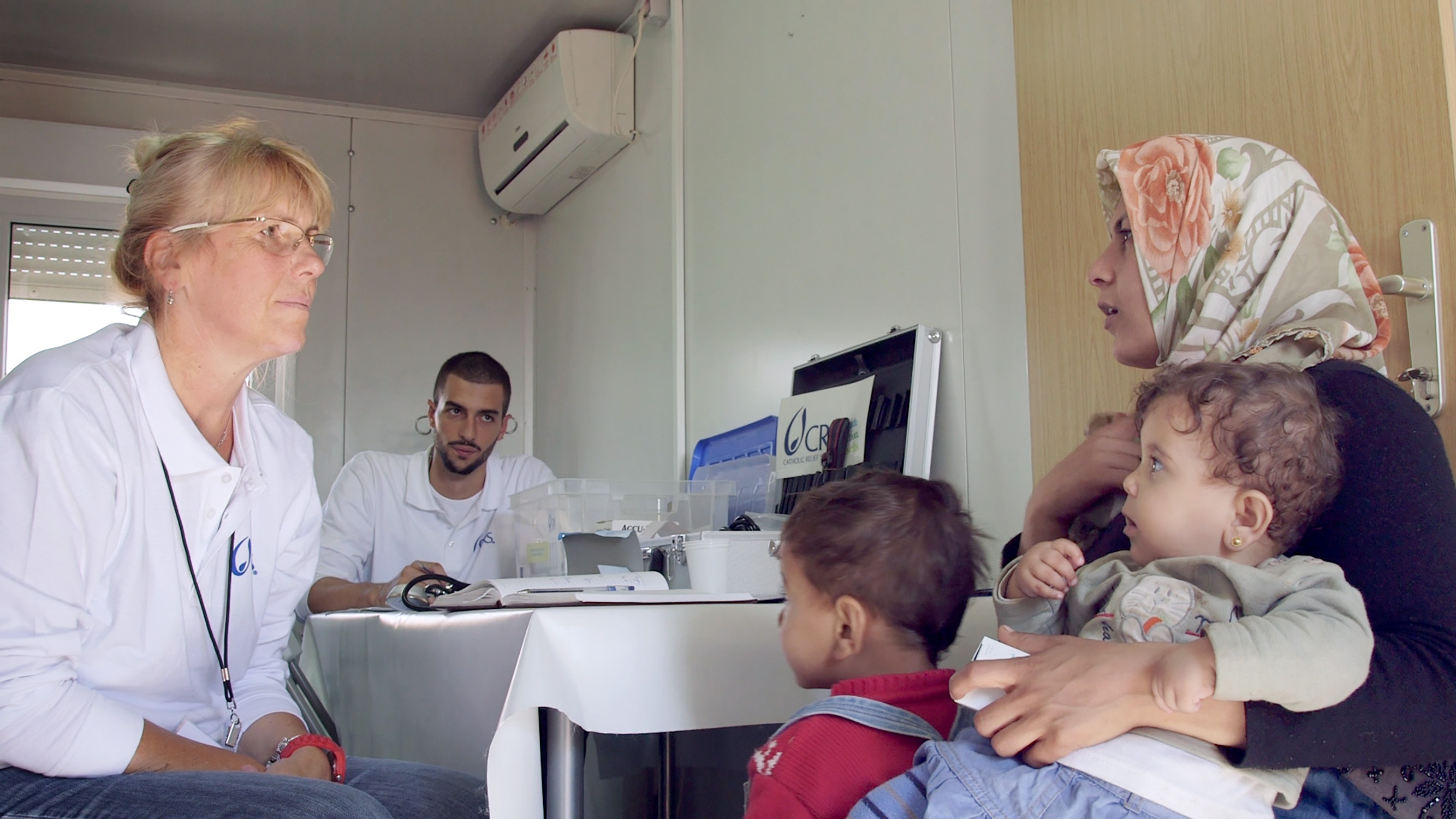 CRS doctor Katarina Mitrovic meets with a refugee family in Serbia. Photo by Oscar Durand for CRS