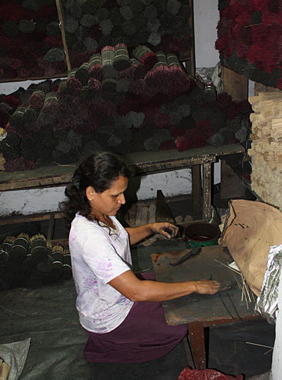 Daya* , 41, rolls incense dough onto sticks. She used a Caritas Kandy loan to build up her incense business, and now employs many part-time workers. Photo by Laura Sheahen/CRS