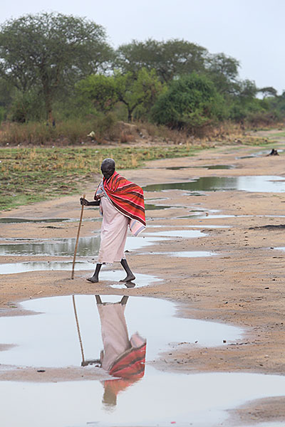 A woman walks along a finished road outside of the village of Makol Cuei in South Sudan. Roads provide access to markets and other villages, and offer safety from attackers. Photo by Sara A. Fajardo/CRS