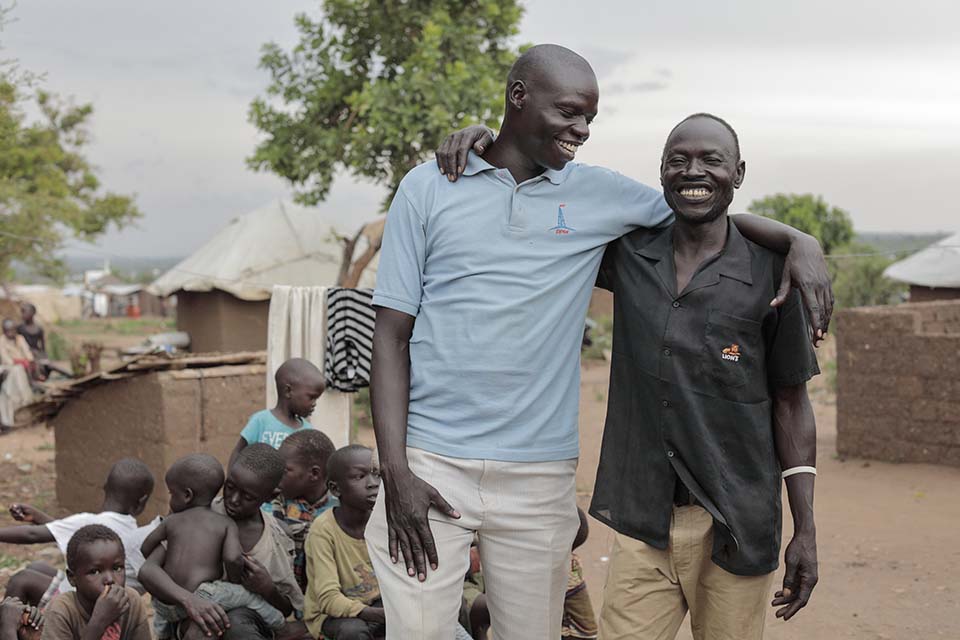 South Sudanese man with arm around his Uganda host friend