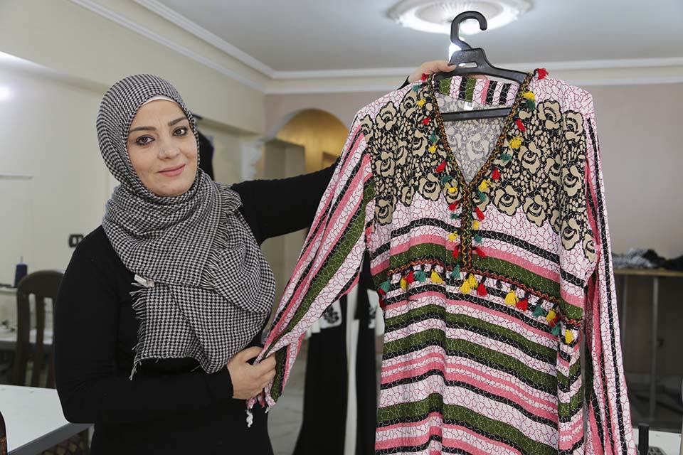 Syrian refugee business woman displays samples of her products