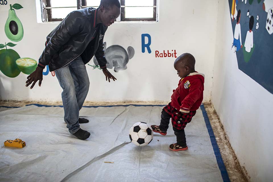Tanzanian father plays ball with his son