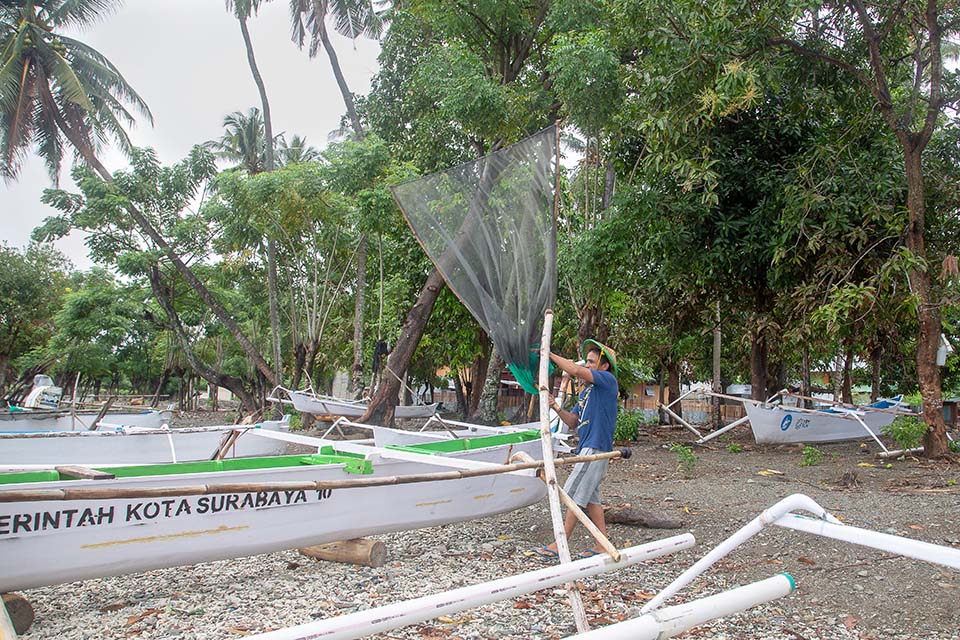 tsunami survivor works fishing net