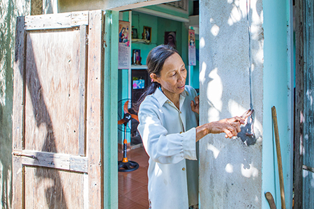Photo by Lisa Murray for CRS Phuoc applies some of the home maintenance skills she learned to ensure her household is storm resilient.