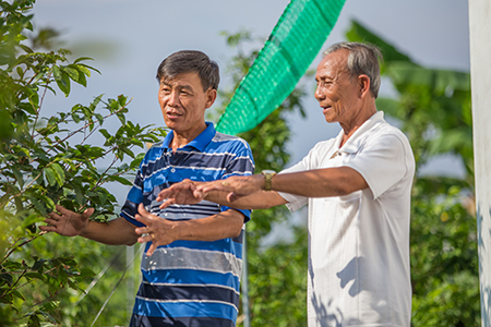 Ba (right) and a neighbor recall losing numerous prized bonsai plants to salty water that resulted from a severe dry spell.