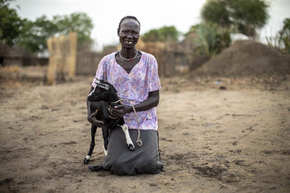 woman holds goat in South Sudan