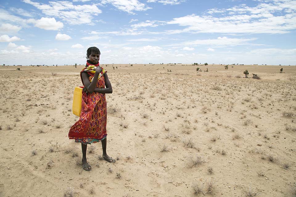 woman in Kenya standing in vast parched landscape