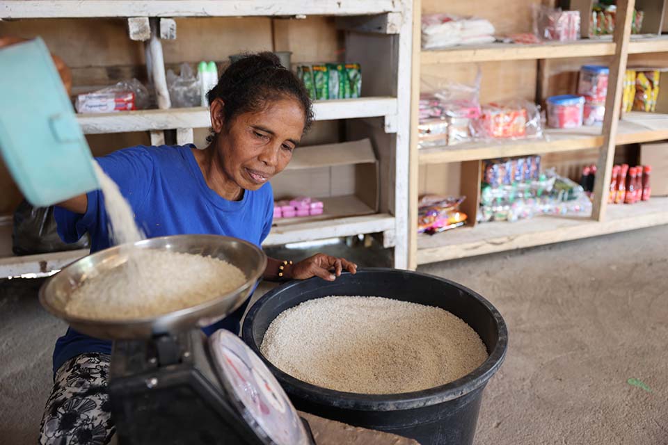 woman measuring grain in Indonesia