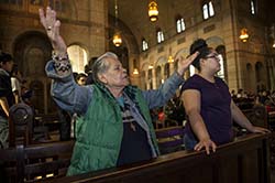 woman prays with outstretched arms