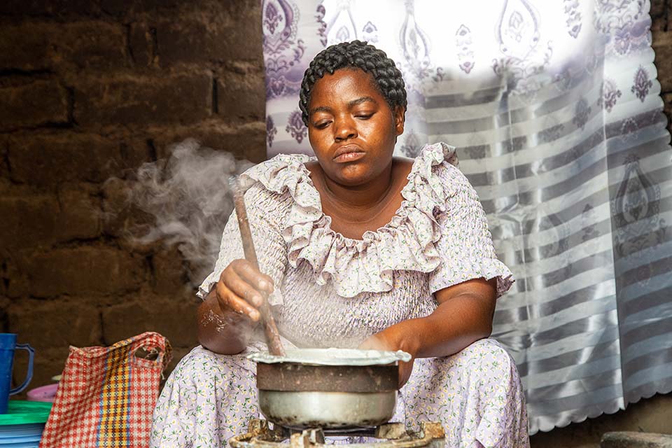 woman prepares porridge in Tanzania