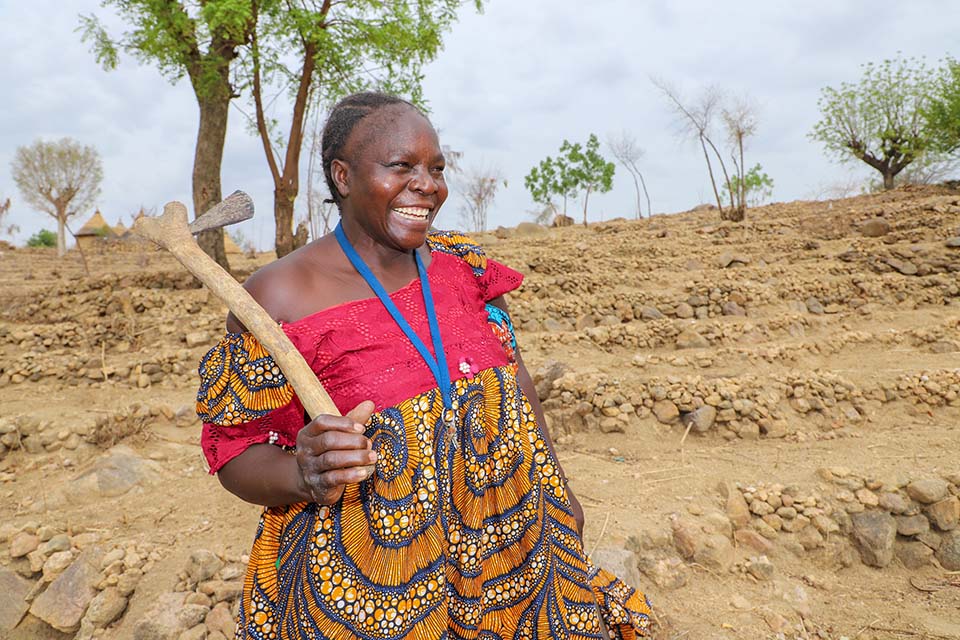 woman smiling holding adze in Cameroon