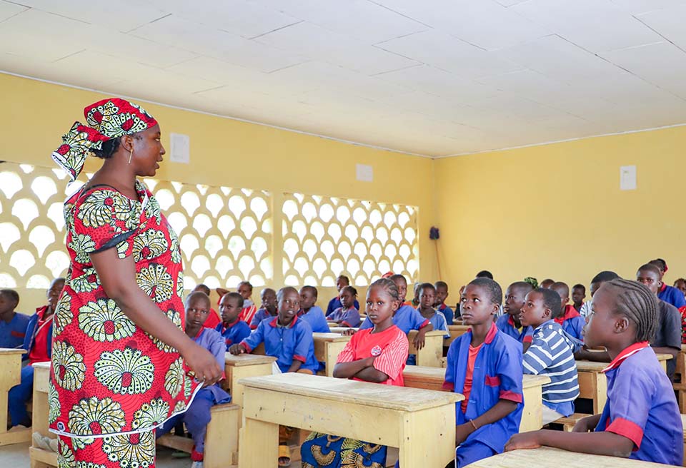woman teaching French to fifth-grade student in Cameroon