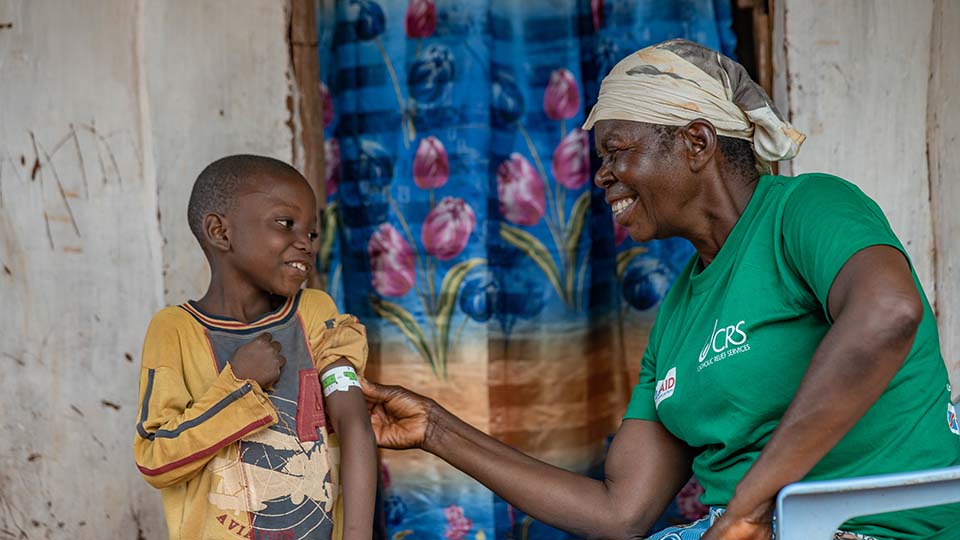 young boy and health worker in DRC