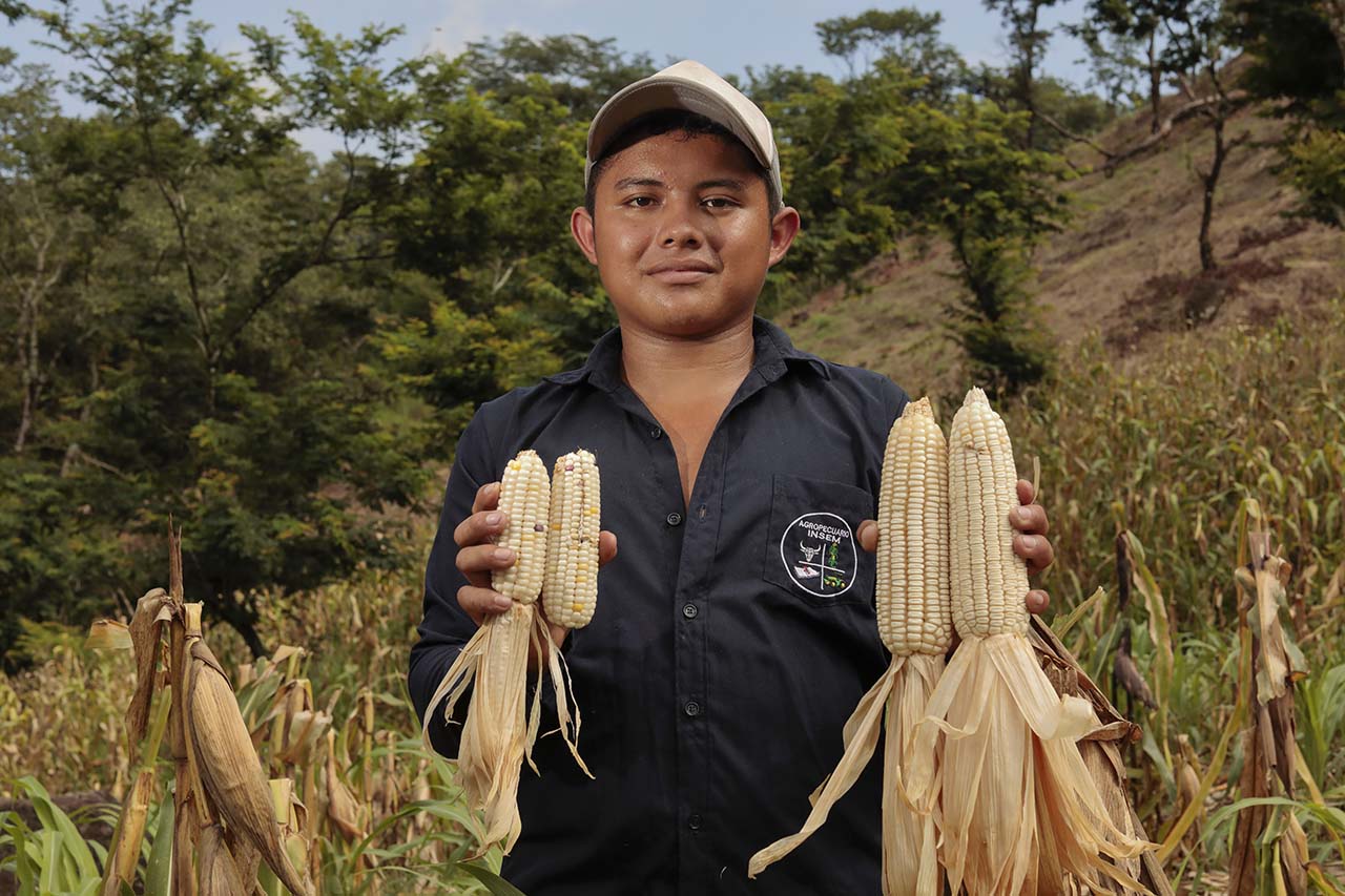 young farmer holding corn in El Salvador