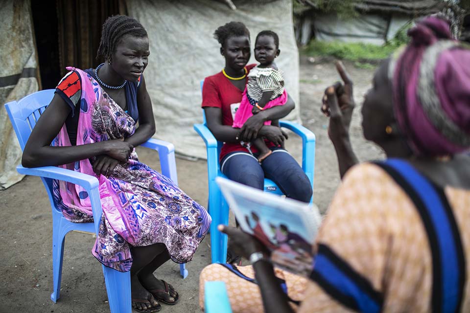young woman listens intently to a speaker in South Sudan