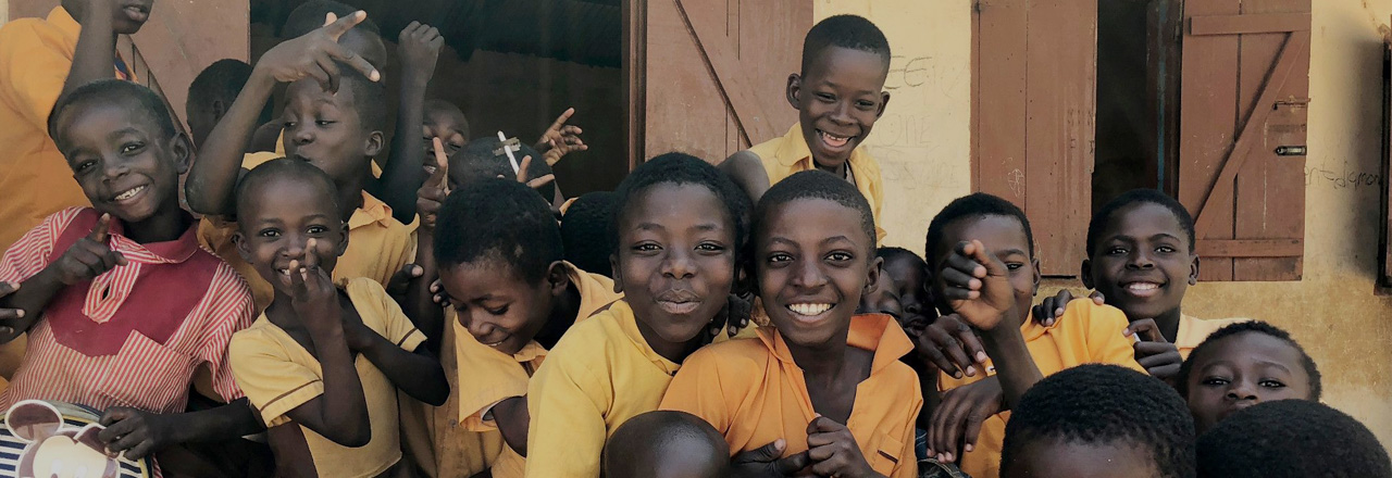 Children in yellow shirts, smiliing.