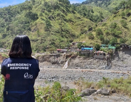 CRS emergency response team member viewing destruction of village due to flooding.