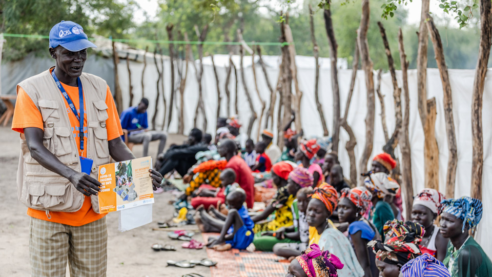 A man showing a paper to a group of people.