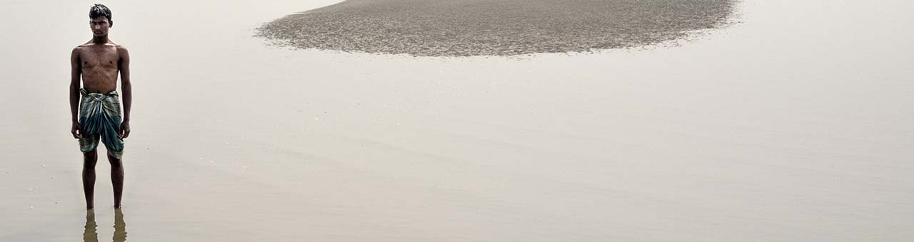 man in Bangladesh standing in shallow water 