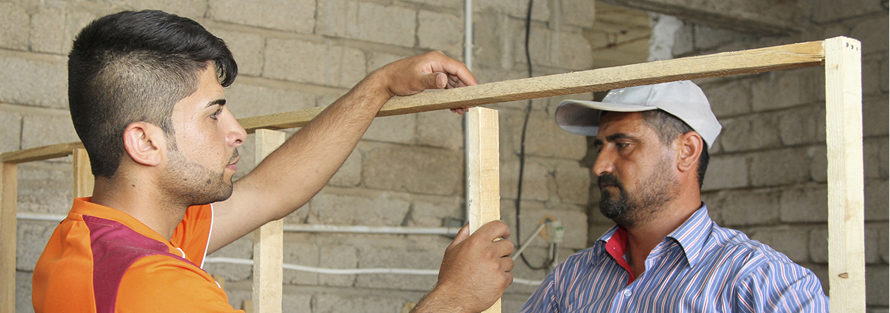 Local volunteers, most of them from the displaced community in northern Iraq, are trained by CRS’ building engineers on basic construction and installing doors and windows in buildings that have become temporary shelters. Photo by Kim Pozniak/CRS