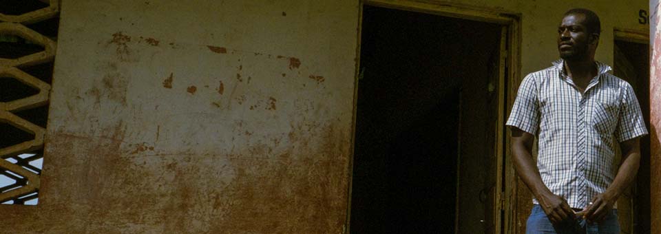 man stands outside school in Guinea Bissau