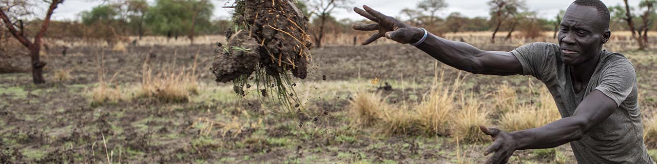 South Sudanese road crew member tossing debris