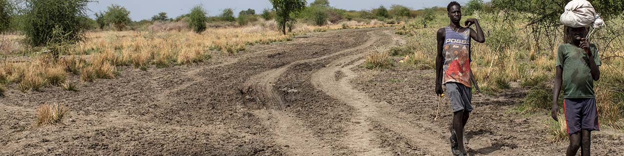 two South Sudanese people walk down a road