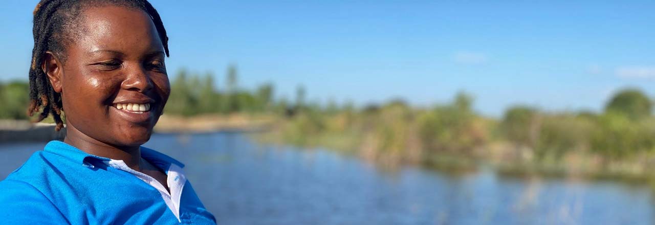 woman smiling near reservoir in Zimbabwe