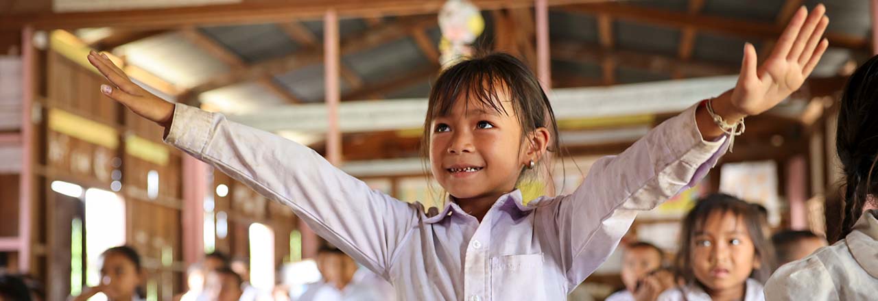 Student with outstretched hands in Laos