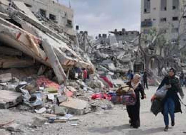 Woman walking around rubble.