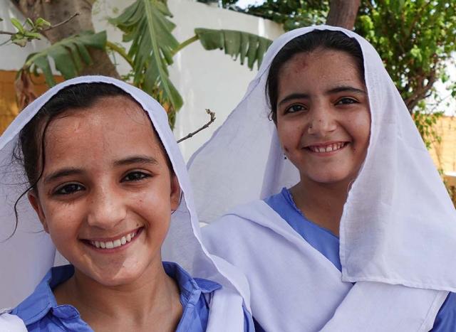 2 young girls in white head scarf.