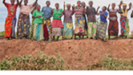 group of Congo citizens standing in a field waving arms