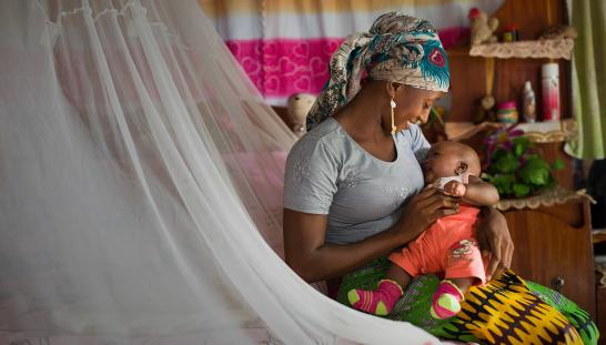 mother and baby under mosquito net