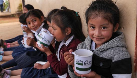 young students outside school with a snack