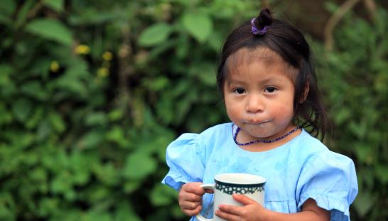 Una niña pequeña tomando leche