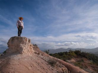 A man looking over a hill.