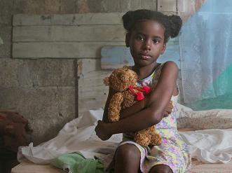 seated young girl holding a yellow teddy bear