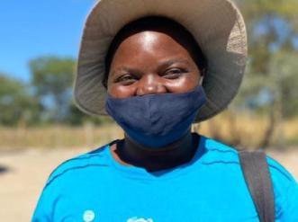young woman with tan hat and blue mask and shirt