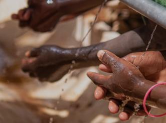 3 pairs of hands washing in clean water