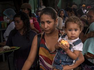refugee mother with children waiting in line