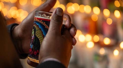hands holding a votive candle in Mexico