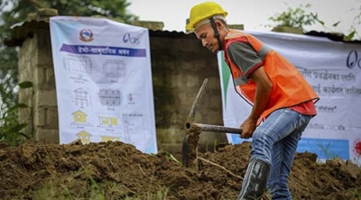 man wearing a hard hat digging a hole