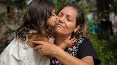 Little girl kisses her mother on the cheek  